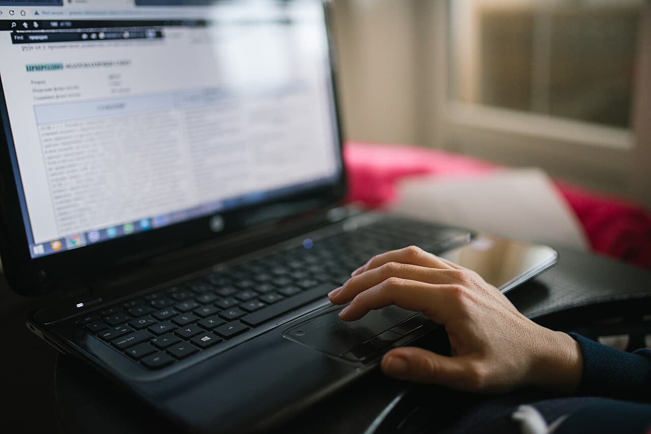 Seseorang sedang bekerja di laptop di ruang kerja yang nyaman